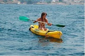 Person paddling a yellow kayak on the water
